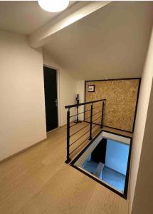 una habitación vacía con una escalera en un edificio en Les Fougères 12 personnes SPA/SAUNA, en Le Tholy