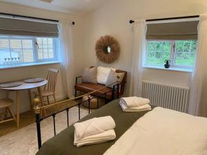 a bedroom with a bed and a table and a chair at Stylish 1 bed studio hot tub &gym close to Lyme in Axminster