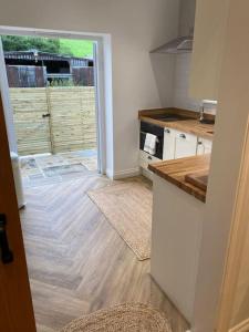 a kitchen with white cabinets and a counter top at Stylish 1 bed studio hot tub &gym close to Lyme in Axminster