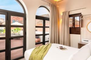 a bedroom with a bed and a large window at Coeo Apart-Hotel Fresca in Málaga