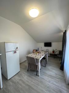 a dining room with a table and a refrigerator at Pensiunea Amira in Năvodari