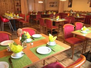 une salle à manger avec des tables en bois et des chaises rouges dans l'établissement Hotel Gasthof Rose, à Guntzbourg