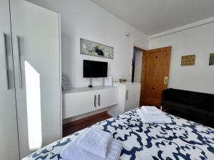 1 dormitorio blanco con 1 cama y TV en RC La Carihuela by Beehive Vacances, en Torremolinos
