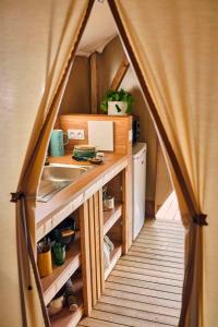 a kitchen in a tiny house with a tent at Camping Rio Purón in Llanes