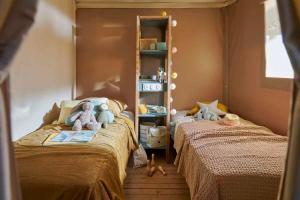 a childs bedroom with two beds with stuffed animals at Camping Rio Purón in Llanes