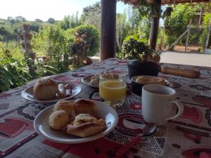 a table with two plates of pastries and orange juice at Pousada Sorocabana in Olímpia