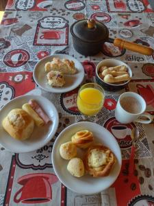 a table with plates of food and cups of coffee at Pousada Sorocabana in Olímpia