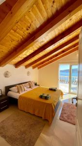 a bedroom with a large bed and a large window at Family House with pool & sea view in Bijela