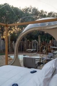 a bed in a tent with a view of a pool at Bubble Room Suite Experience - Bolla Savio Ravenna in Savio di Ravenna