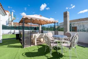 un patio con mesa, sillas y sombrilla en Hauzify I Villa Magalí, en Les tres Cales