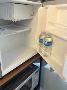 Zwei Flaschen Wasser stehen in einem offenen Kühlschrank. in der Unterkunft Private En-suite in Birmingham