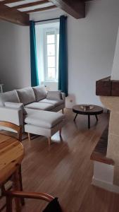 ein Wohnzimmer mit einem Sofa und einem Tisch in der Unterkunft Chez Maria Maison de bourg 4 Ch + jardin in Legé
