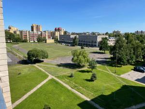 an empty park with trees and buildings in the background at Cozy Urban Retreat in Panevėžys