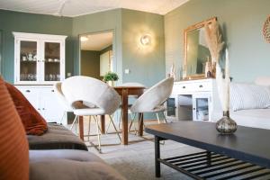 a living room with a table and white chairs at Das Hinterhaus in Beeskow