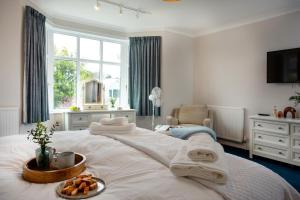 a bedroom with a bed with a tray of food on it at Toller House in Exmouth
