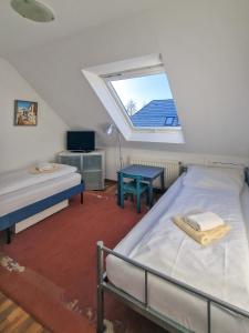um quarto no sótão com 2 camas e uma janela em Sonnenhus em Greetsiel