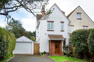 uma casa branca com garagem em Toller House em Exmouth