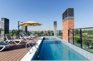 a swimming pool with chairs and an umbrella on a building at Distinguished And Elegant Apartment 2 Bedroom in Asuncion