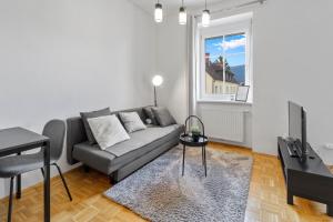a living room with a couch and a table and a window at StayEasy Apartments Krieglach W1 