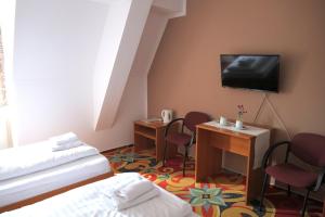 Habitación de hotel con 2 camas y TV de pantalla plana. en Zámecký Penzion, en Valašské Meziříčí
