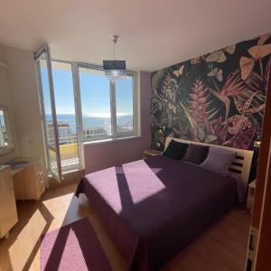 een slaapkamer met een paars bed en een groot raam bij Crown Imperial Fort Grand Resort in Elenite