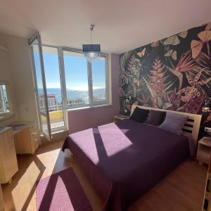 a bedroom with a purple bed and a large window at Crown Imperial Fort Grand Resort in Elenite