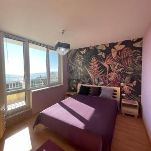 1 dormitorio con cama morada y pared de flores en Crown Imperial Fort Grand Resort en Elenite