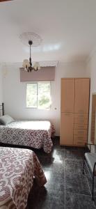 1 dormitorio con 2 camas y ventana en Casa Bermúdez, en Setenil