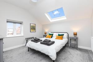 a bedroom with a bed with orange and green pillows at The Old Bakery Angmering in Angmering