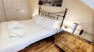 a bedroom with a white bed and a dresser at Apartment 4 - striking, 2 bedroom luxury apartment - close to town, mainline rail & theatre in Darlington