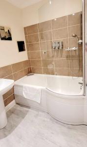 a bathroom with a shower and a tub and a sink at Apartment 4 - striking, 2 bedroom luxury apartment - close to town, mainline rail & theatre in Darlington