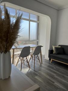 ein Wohnzimmer mit einem Tisch, Stühlen und einem Sofa in der Unterkunft Piso Universidad Alicante in San Vicente del Raspeig