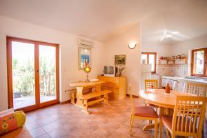 een woonkamer met een tafel en een keuken bij Apartment Beach Stara Porozina in Porozina