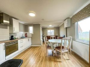 a kitchen and dining room with a table and chairs at 5 Berth Dog Friendly Lodge In Hunstanton By The Beach Ref 13015rn in Hunstanton