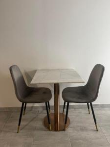 una mesa y dos sillas sentadas una al lado de la otra en L’Eden Centre ville, en Melun