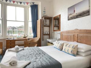a bedroom with a bed and a sink in a room at Seascape guest house in Melcombe Regis