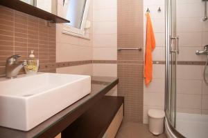 a bathroom with a white sink and a shower at Apartmani Miš Rab in Palit +25 photos