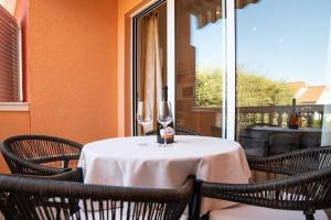 a table with two wine glasses on top of it at Apartmani Miš Rab in Palit