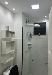 uma casa de banho branca com um chuveiro e um WC. em Próx Aeroporto Confins e Belo-Horizonte, Cidade do Galo, Mega Space em Vespasiano