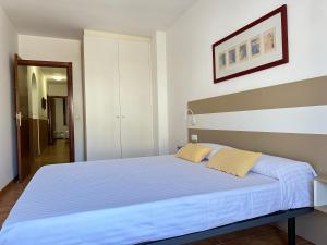 een slaapkamer met een groot bed met blauwe lakens bij Agi Pere Lluis in Roses