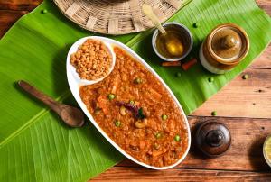 a bowl of food on top of a banana leaf at Hotel Twin Tulips HSR Layout in Bangalore