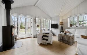 uma sala de estar com mobiliário branco e janelas em 3 Bedroom Amazing Home In Frederiksvrk em Frederiksværk
