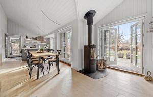 uma cozinha e sala de jantar com um fogão a lenha em 3 Bedroom Amazing Home In Frederiksvrk em Frederiksværk