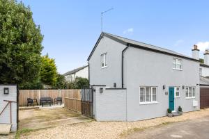 a white house with a fence at The Old Bakery Angmering in Angmering