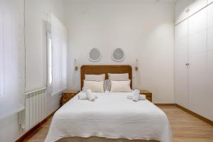una camera da letto con un grande letto bianco con due cuscini di 2 bedrooms 2 bathrooms furnished - Chamberi - modern - MintyStay a Madrid