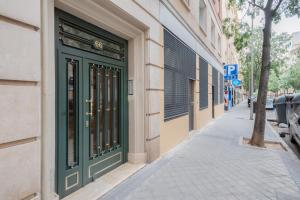 una porta verde sul lato di un edificio di 2 bedrooms 2 bathrooms furnished - Chamberi - modern - MintyStay a Madrid