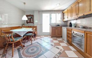a kitchen with a table and chairs in it at Stunning Apartment In Castell De La Plana With Kitchen in Castellón de la Plana