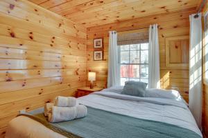 um quarto com uma cama num chalé de madeira em Laconia Cabin Rental Less Than 1 Mi to Lake Winnipesaukee! em Laconia