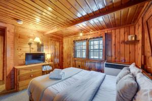 sypialnia z łóżkiem i telewizorem oraz drewnianymi ścianami w obiekcie Laconia Cabin with Grill 2 Mi to Weirs Beach! w mieście Laconia