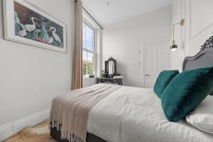 a bedroom with a bed with green pillows and a window at Pelican Suite 1 Bed Apartment in Harrogate